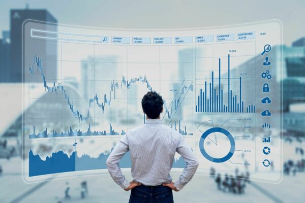 A man looking at financial performance graphics on an hologramic screen