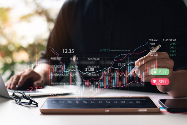Tablet showing digital stock chart with hands nearby